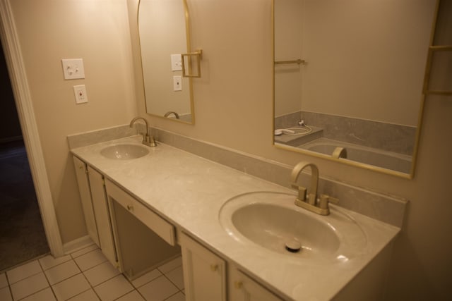 full bath with double vanity, tile patterned flooring, and a sink