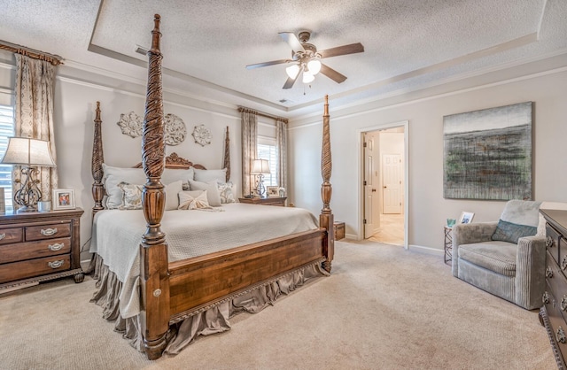 bedroom with baseboards, carpet flooring, a textured ceiling, and a tray ceiling