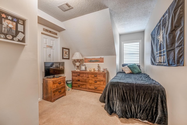 bedroom with visible vents, lofted ceiling, carpet, and a textured ceiling