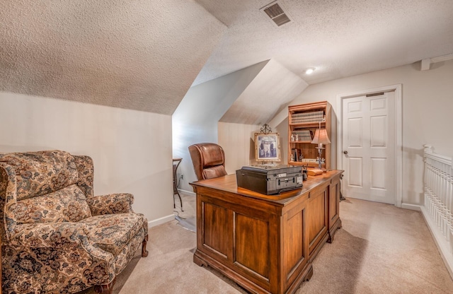 office space featuring visible vents, light colored carpet, and vaulted ceiling