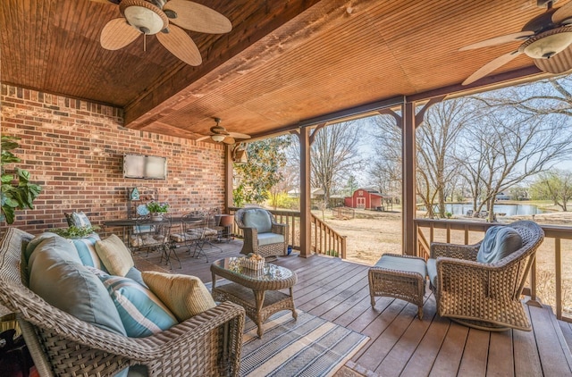 deck featuring ceiling fan, an outdoor hangout area, outdoor dining space, and a water view