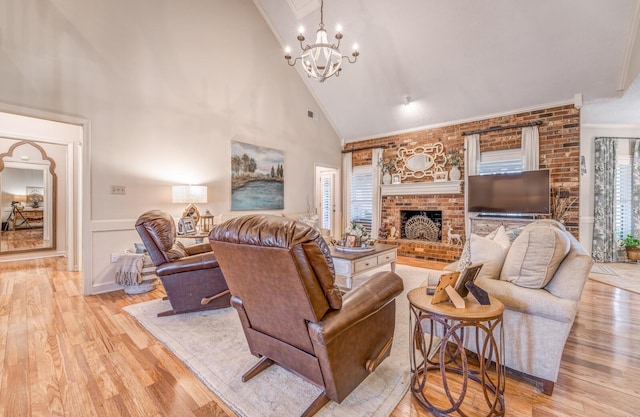 living area featuring light wood-type flooring, visible vents, ornamental molding, a brick fireplace, and a chandelier