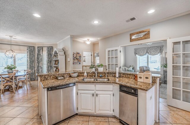 kitchen featuring visible vents, ornamental molding, a sink, stone counters, and dishwasher