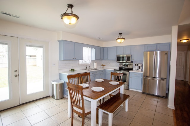 kitchen with visible vents, a sink, stainless steel appliances, light countertops, and tasteful backsplash