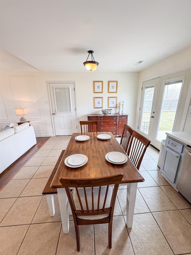 dining room featuring visible vents, light tile patterned flooring, and french doors