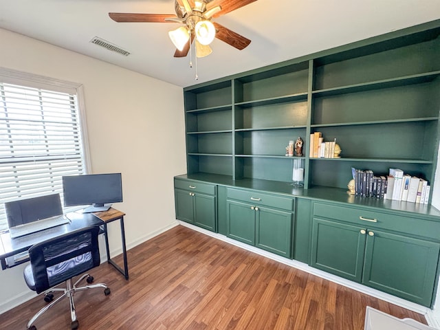 office space featuring visible vents, baseboards, dark wood-style flooring, and a ceiling fan