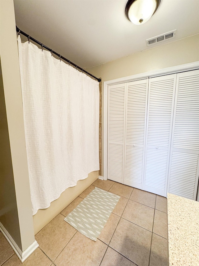 bathroom with tile patterned floors, visible vents, and shower / bath combination with curtain