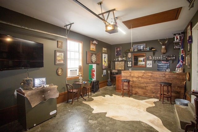 interior space with a dry bar, attic access, and concrete flooring