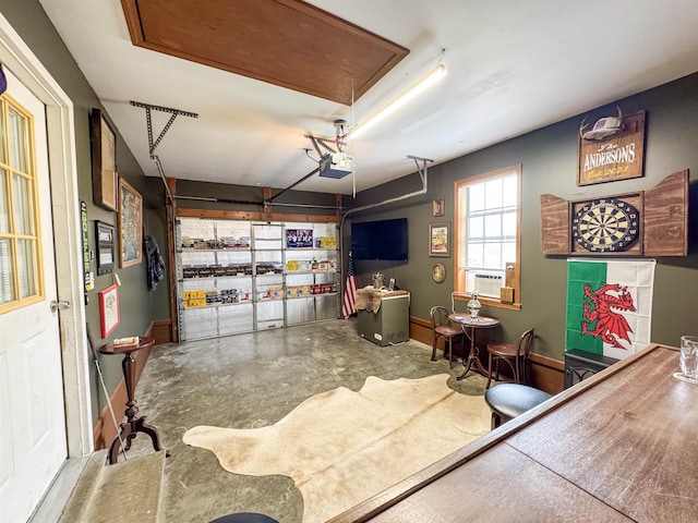 interior space featuring cooling unit, baseboards, a garage, and concrete flooring