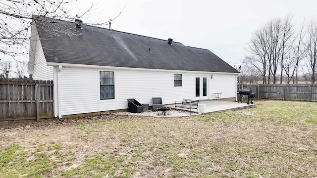 back of house featuring a fire pit, a shingled roof, a lawn, a fenced backyard, and a patio