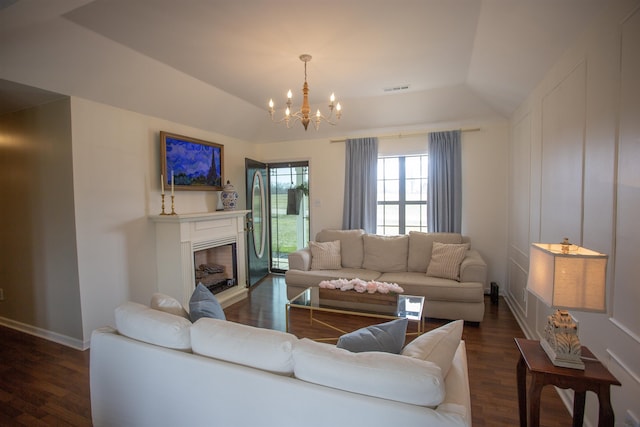 living area with dark wood-style floors, a notable chandelier, a raised ceiling, and visible vents