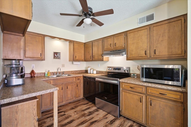 kitchen featuring visible vents, under cabinet range hood, a sink, stainless steel appliances, and ceiling fan