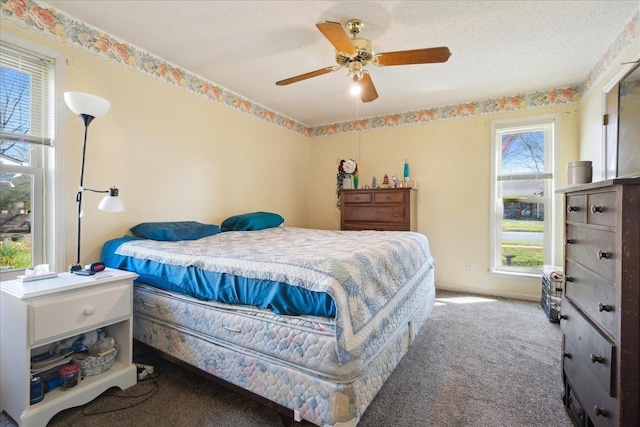 bedroom featuring ceiling fan, a textured ceiling, and carpet