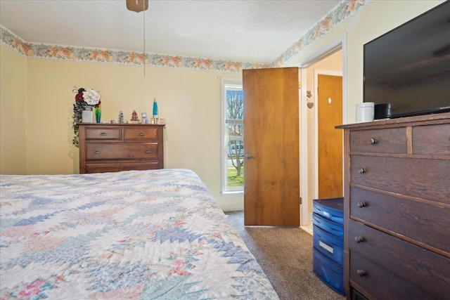 bedroom with a ceiling fan, multiple windows, a textured ceiling, and carpet flooring