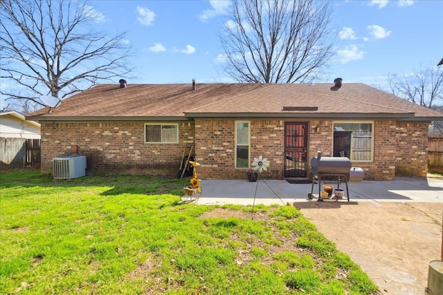 back of property with fence, a yard, central AC, a patio area, and brick siding