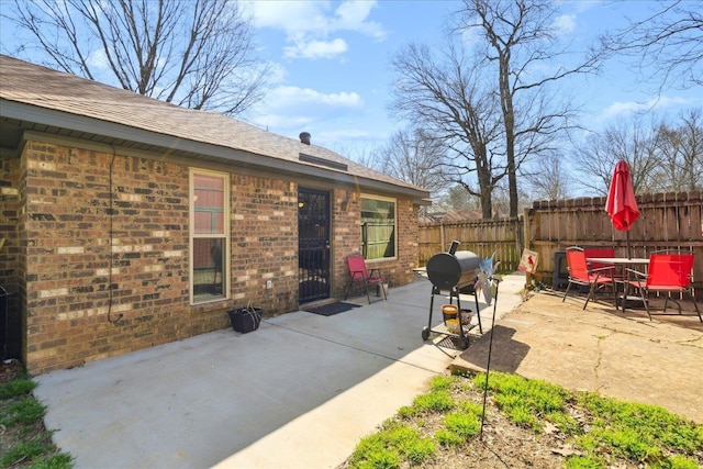 view of patio featuring area for grilling, outdoor dining space, and fence