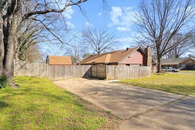 view of yard featuring concrete driveway and fence