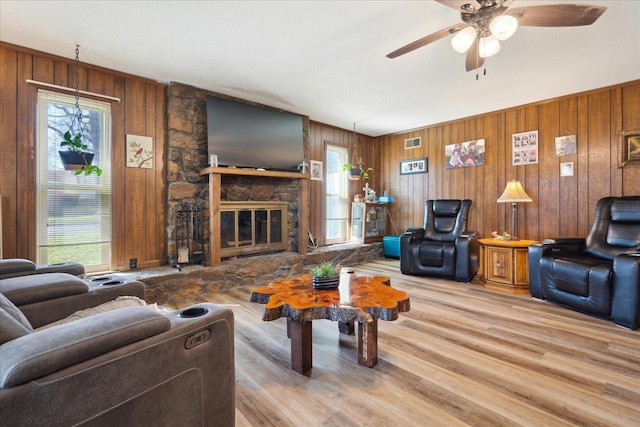 living area featuring plenty of natural light, visible vents, ceiling fan, and wood finished floors