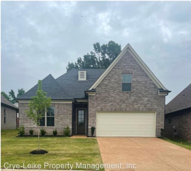 view of front of property featuring brick siding, a front lawn, concrete driveway, and an attached garage