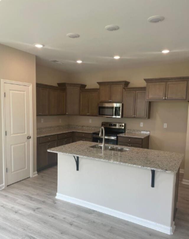7718 Parkridge Dr, Southaven, MS 38671 - kitchen featuring a sink, light wood-type flooring, an island with sink, and stainless steel appliances