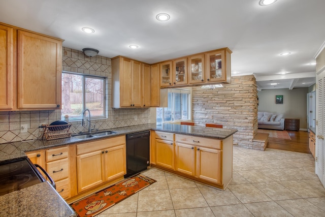 kitchen with a peninsula, light tile patterned flooring, a sink, decorative backsplash, and black appliances