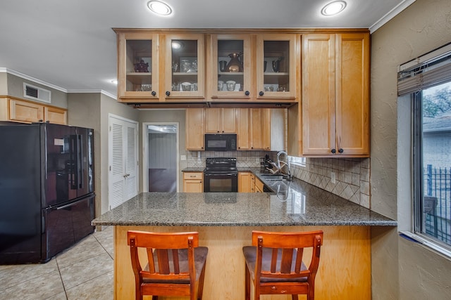 kitchen featuring visible vents, black appliances, a sink, a peninsula, and light tile patterned floors