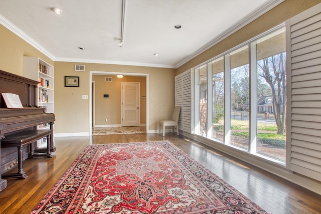 sitting room featuring crown molding, wood finished floors, visible vents, and baseboards