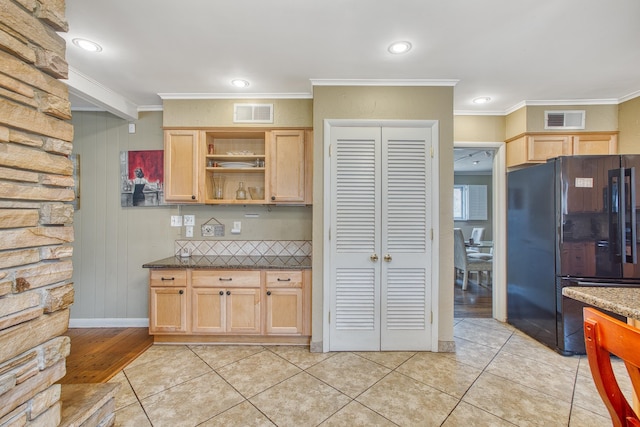 kitchen with light brown cabinets, visible vents, light tile patterned flooring, freestanding refrigerator, and ornamental molding