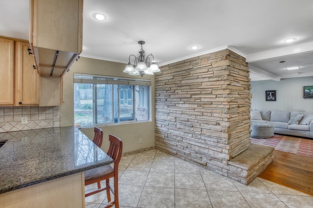 dining area featuring light tile patterned flooring, a notable chandelier, and crown molding