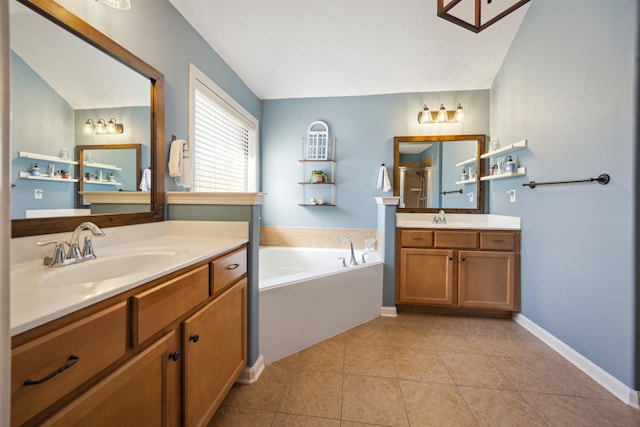 bathroom featuring tile patterned floors, a shower stall, two vanities, and a sink