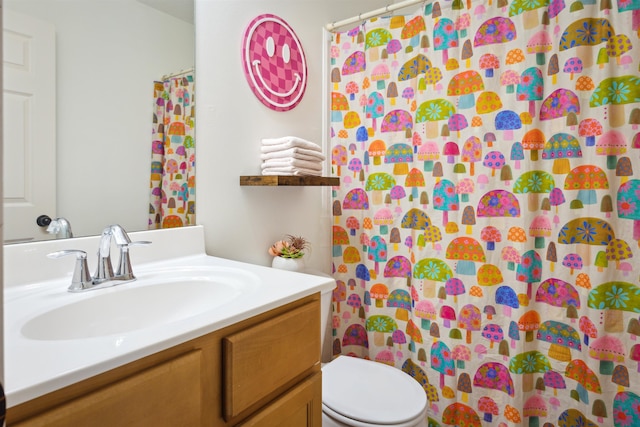 bathroom with curtained shower, toilet, and vanity