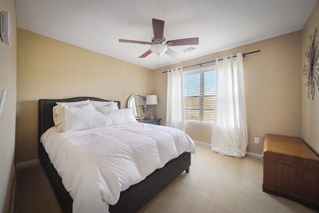 carpeted bedroom featuring visible vents, baseboards, and a ceiling fan