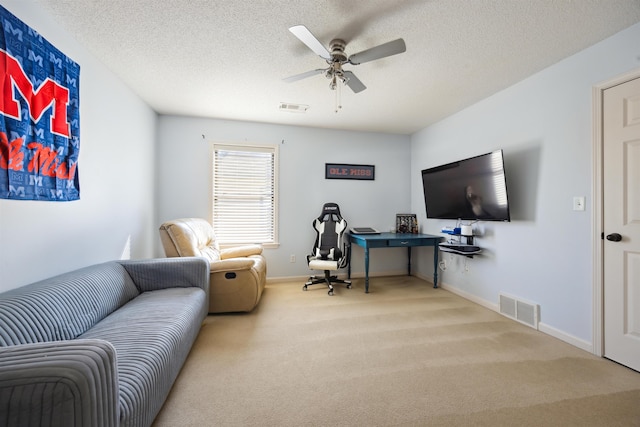 carpeted office space with visible vents, a textured ceiling, and a ceiling fan