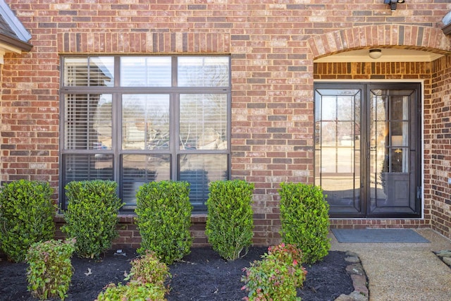 entrance to property featuring brick siding