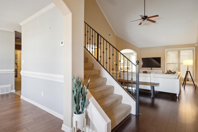 stairway with a ceiling fan, wood finished floors, visible vents, arched walkways, and crown molding