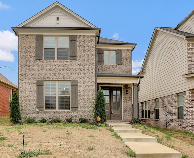 traditional-style house featuring french doors and brick siding