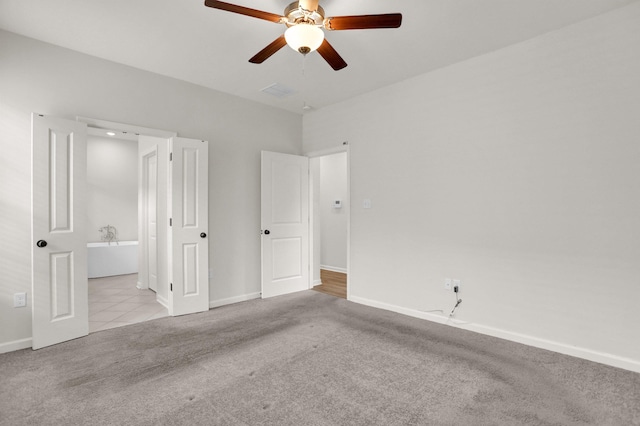 unfurnished bedroom featuring ceiling fan, baseboards, ensuite bath, and carpet flooring