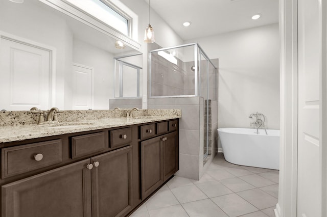 full bath with double vanity, a stall shower, a freestanding tub, tile patterned floors, and a sink