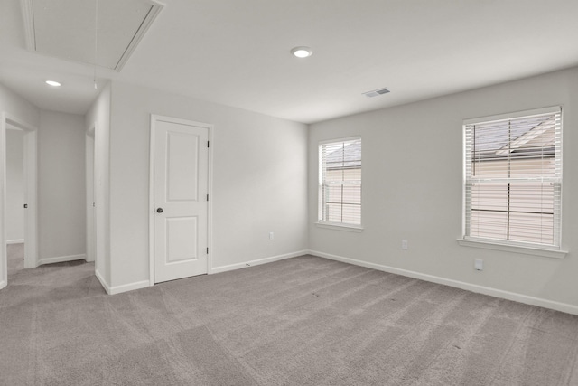 carpeted spare room featuring visible vents, recessed lighting, attic access, and baseboards