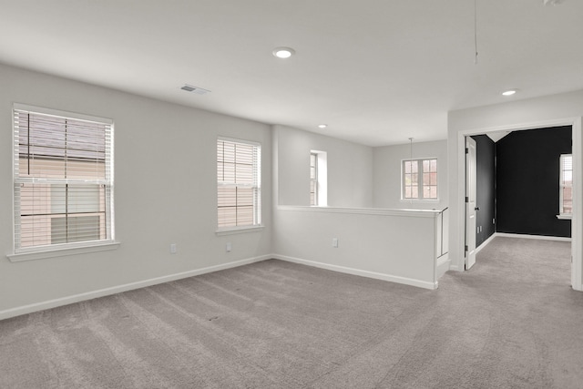 spare room featuring recessed lighting, light colored carpet, visible vents, and baseboards