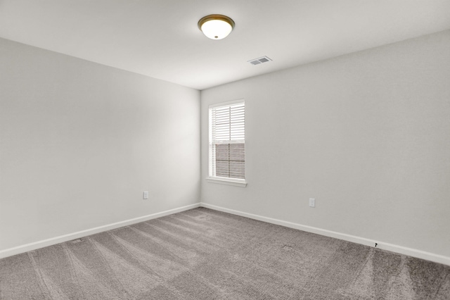 empty room featuring visible vents, baseboards, and carpet flooring