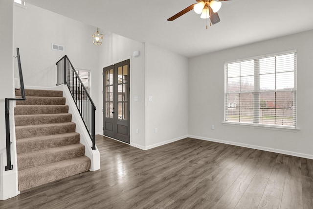 interior space with visible vents, stairs, a ceiling fan, and wood finished floors