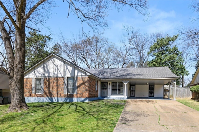 view of front facade featuring fence, driveway, a front lawn, a carport, and brick siding