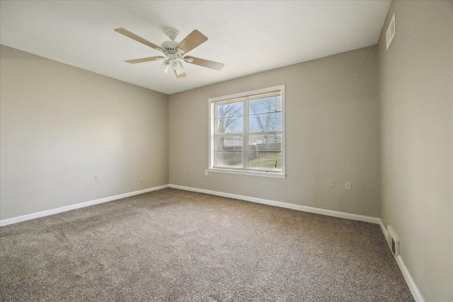 carpeted empty room with visible vents, ceiling fan, and baseboards