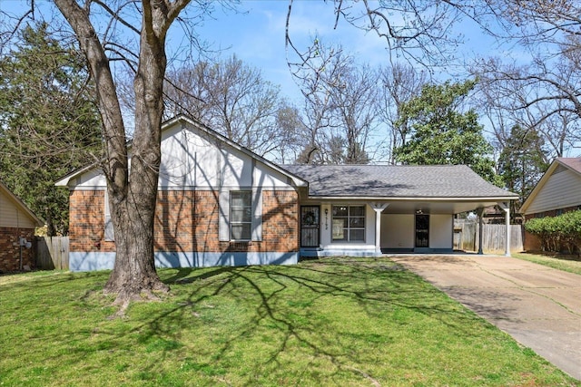 view of front of house with a front lawn, an attached carport, fence, concrete driveway, and brick siding