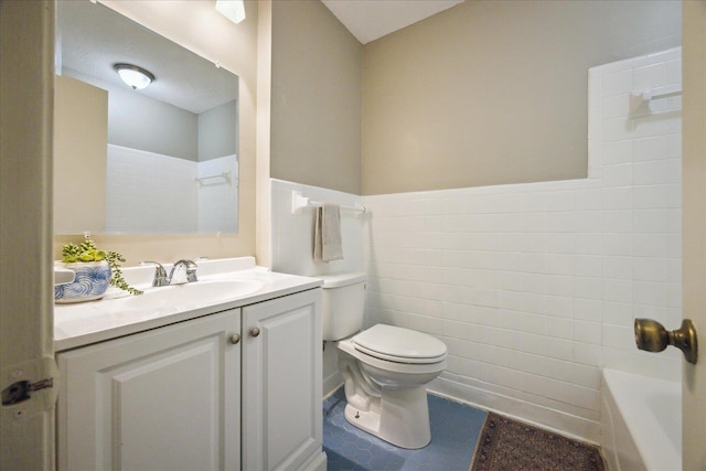 bathroom featuring a wainscoted wall, toilet, vanity, a bathing tub, and tile walls