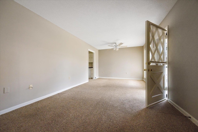 carpeted empty room with a textured ceiling, baseboards, and ceiling fan