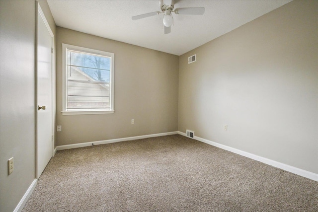 empty room with baseboards, carpet flooring, a ceiling fan, and visible vents