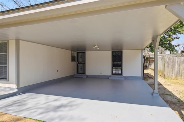 view of patio with an attached carport and fence