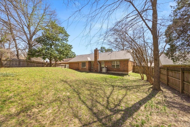 view of yard with central air condition unit and a fenced backyard